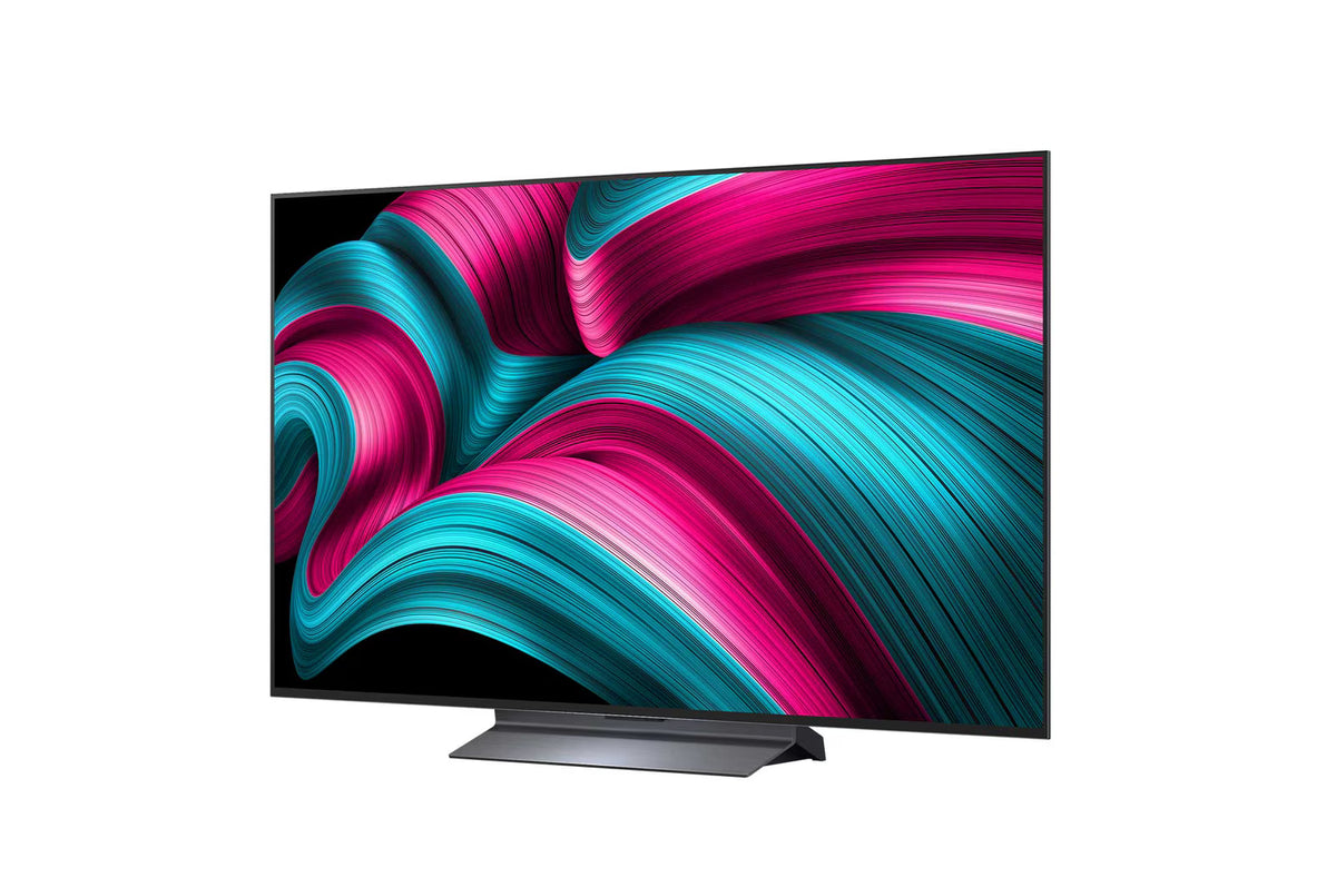 LG 65C5 OLED Televízió előlnézetben, talpon. A kijelzőn pirosas kék absztrakt ábrák.