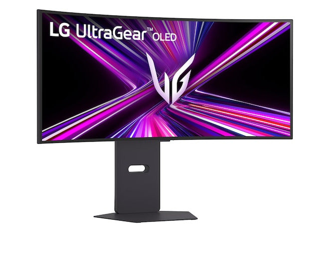 LG 39GX900A-B monitor előlnézetben talpon, enyhén jobbra fordítva. A képernyőn lg ultragear oled logó és rózsaszín lilás absztrakt ábra.