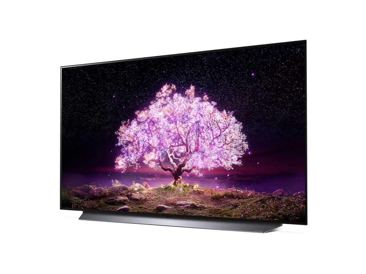 LG 48C1 OLED televízió előlnézetben enyhén balra fordítva talpon, a kijelzőn csillagos égbolt és rózsaszínben világító fa.