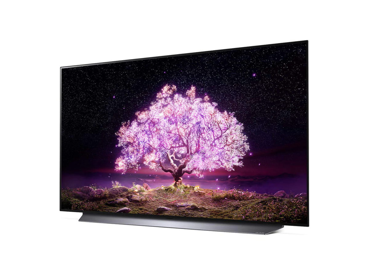 LG 77C1 OLED televízió előlnézetben enyhén balra fordítva talpon, a kijelzőn csillagos égbolt és rózsaszínben világító fa.