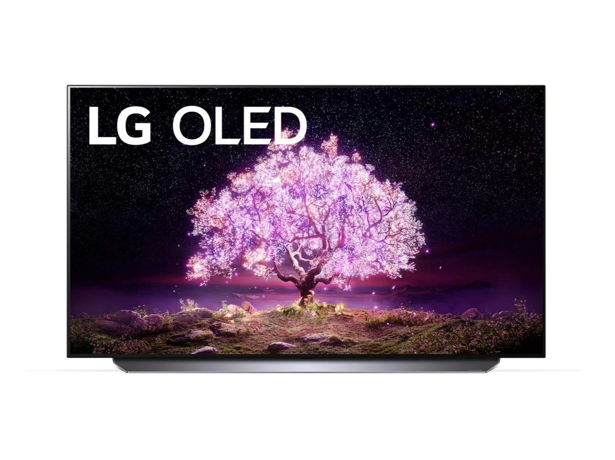 LG 77C1 OLED televízió előlnézetben talpon, a kijelzőn csillagos égbolt és rózsaszínben világító fa, oled logóval.